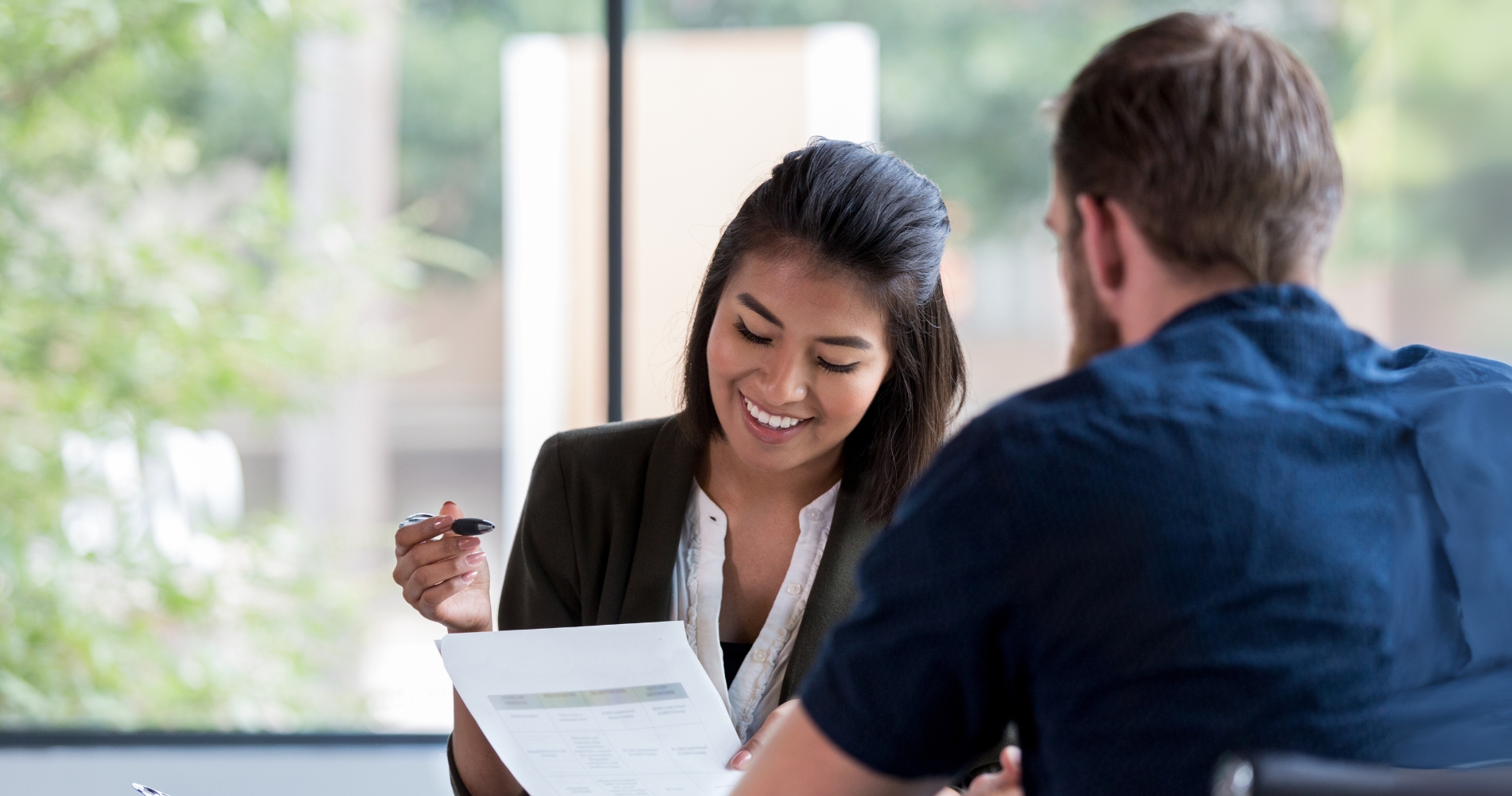 A mortgage advisor explains loan options to a client, highlighting key differences between FHA and conventional loan APRs during a financial consultation.